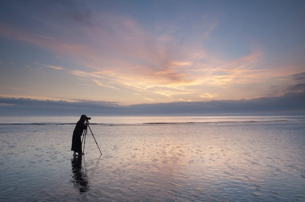 Picture of a person taking a photo on a sunset beach